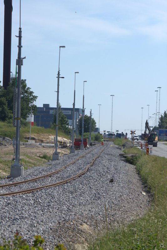 Ny ballast, oriktat spår och kontaktledningsstolpar med belysning längs S. Stillerydsvägen.