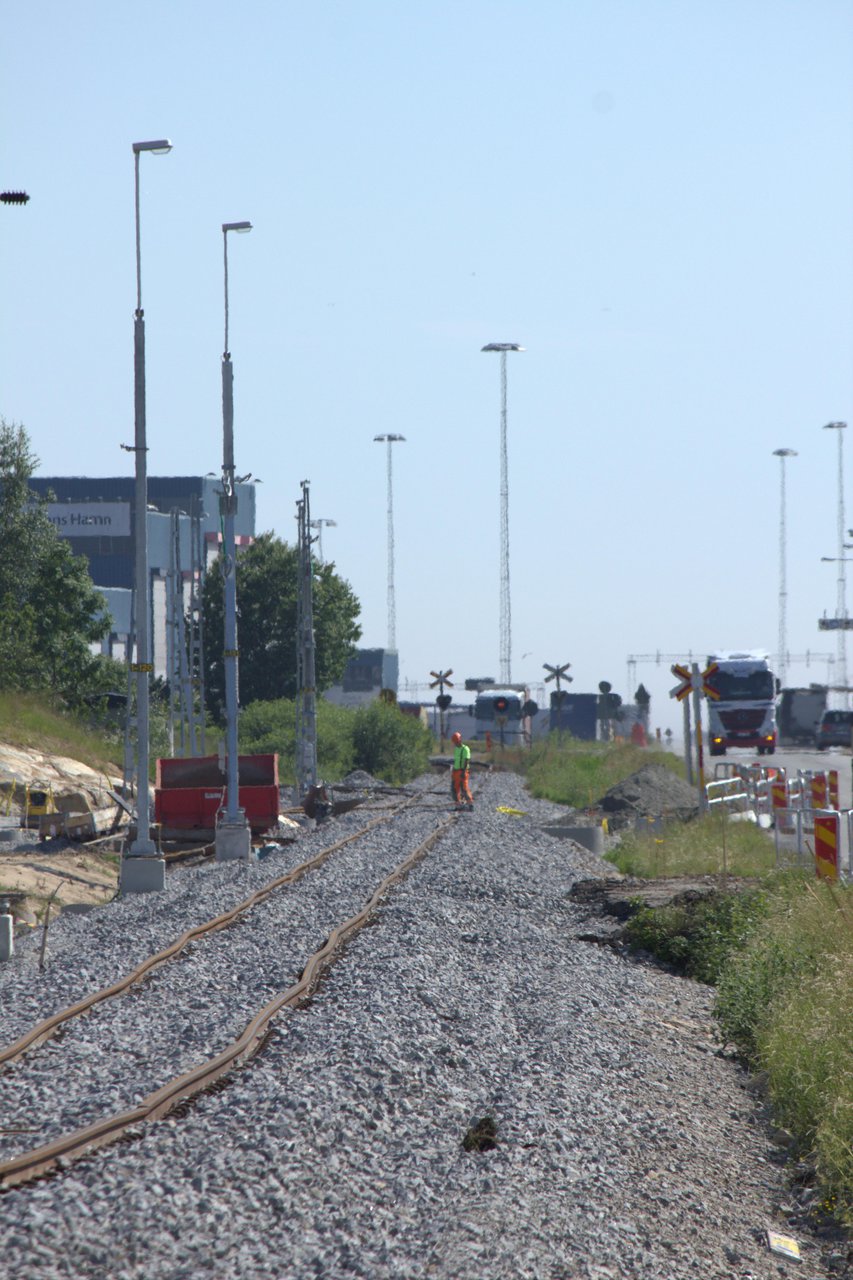 Ny ballast, oriktat spår och kontaktledningsstolpar med belysning längs S. Stillerydsvägen.