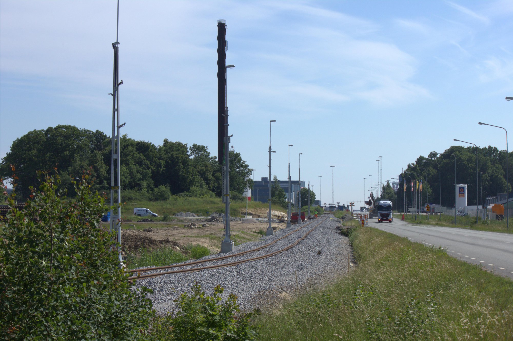 Ny ballast, oriktat spår och kontaktledningsstolpar med belysning längs S. Stillerydsvägen.